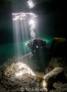 "Into the Light".
Diver in sunbeams in Taj Maha Cenote, ... by Nick Blake 